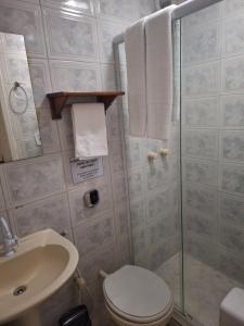 a bathroom with a shower and a toilet and a sink at Pousada Areias Brancas in Búzios