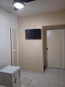 a room with a door and a television on the wall at Pousada Areias Brancas in Búzios