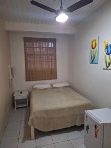 a bedroom with a bed and a ceiling fan at Pousada Areias Brancas in Búzios