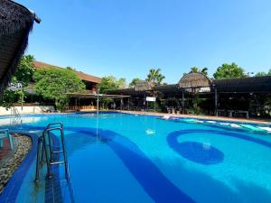 a large swimming pool with blue water at บ้านนกฮูกอิงไม้ ริมเล in Ban Khlong Sai