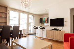 uma sala de estar com uma mesa e uma televisão em Au pied de la Tour Eiffel résidence familiale 2bdr em Paris