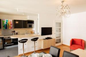 uma sala de estar com uma cozinha com mesa e cadeiras em Au pied de la Tour Eiffel résidence familiale 2bdr em Paris