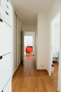 um corredor de um apartamento com piso de madeira em Au pied de la Tour Eiffel résidence familiale 2bdr em Paris