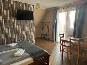 ein Schlafzimmer mit einem Bett und einem Tisch und einem Fernseher in der Unterkunft Pokoje Gościnne Bartuś in Czarna Góra + 14 Fotos