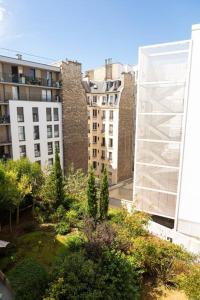 um jardim no meio de uma cidade com edifícios em Au pied de la Tour Eiffel résidence familiale 2bdr em Paris