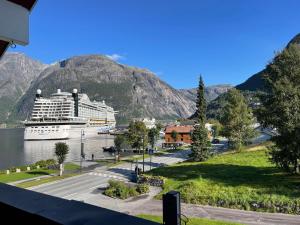 een cruiseschip in het water met een berg bij Ingrids Apartments in Eidfjord