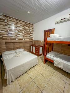 a room with two beds and a bunk bed at pousada Vitoria in Morro de São Paulo
