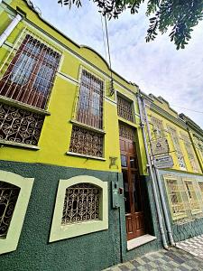a green building with windows and a door at Hostel Manaus in Manaus