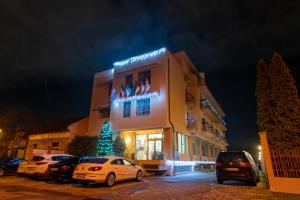 budynek z samochodami zaparkowanymi na parkingu w nocy w obiekcie Hotel Oxford Inns&Suites w mieście Timişoara