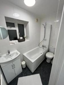 a white bathroom with a sink and a toilet at Contemporary Style in the Heart of London in London