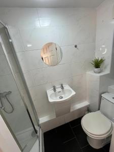 a white bathroom with a toilet and a sink at Contemporary Style in the Heart of London in London