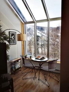 um quarto com uma mesa e cadeiras e uma grande janela em Condo sur 2 niveaux avec magnifique vue sur la montagne em Stoneham