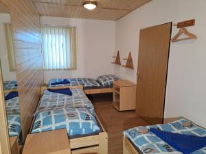 Schlafsaal mit 4 Betten und einem Tisch in der Unterkunft Apartmán Albrecht in Albrechtice v Jizerských horách