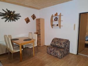 ein Esszimmer mit einem Tisch, Stühlen und einem Regal in der Unterkunft Apartmán Albrecht in Albrechtice v Jizerských horách