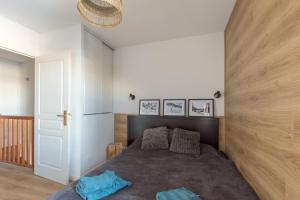 een slaapkamer met een bed met een houten muur bij Chalet Orée des pistes - Piscine et sauna in Les Orres