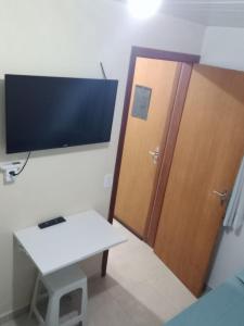 a room with a door and a television and a table at AP Floripa in Florianópolis