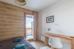 een slaapkamer met een bed, een bureau en een raam bij Chalet Orée des pistes - Piscine et sauna in Les Orres