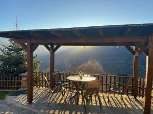 eine Terrasse mit einem Tisch und Stühlen auf einer Terrasse in der Unterkunft Πέτρινο Όραμα in Kotrónion