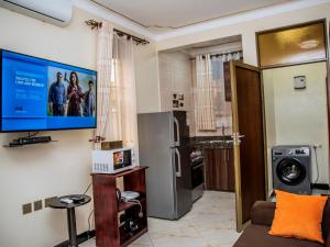 a living room with a flat screen tv on the wall at Studio Furnished Apartments Entebbe in Entebbe