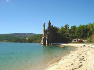 ein Strand mit einem großen Felsen im Wasser in der Unterkunft Gem of Viso in Setúbal