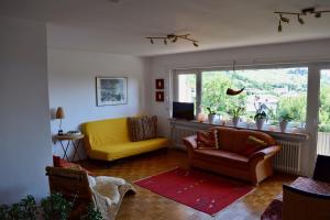 - un salon avec un canapé jaune et une fenêtre dans l'établissement Ferienwohnung Ruth, à Neustadt an der Weinstraße