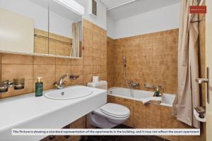 uma casa de banho com um lavatório, um WC e uma banheira em Beautiful Boutique Apartment DRAHTZUG8 em Zürich