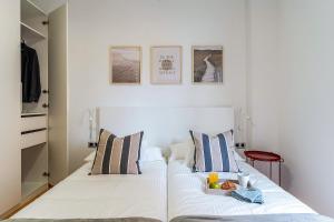 Una cama blanca con una bandeja de fruta. en 4207 - AB Sant Adria de Besos, en Barcelona