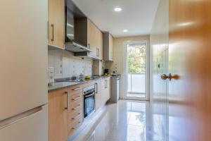a large kitchen with white cabinets and a window at 4207 - AB Sant Adria de Besos in Barcelona