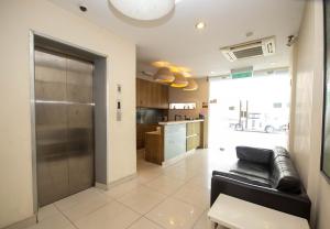 a living room with a couch and a kitchen at JQ Station Eight Inn in Ipoh