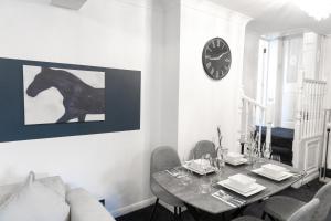 a dining room with a table and a clock on the wall at Modern 4 bedroom Burnham Slough in Burnham