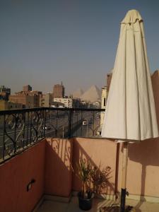 a white umbrella sitting on top of a balcony at Pyramids Road in Cairo