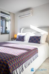ein Schlafzimmer mit einem großen weißen Bett und einem Fenster in der Unterkunft Porto Formosa Central Lofts in Porto