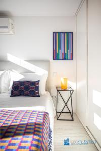 Schlafzimmer mit einem Bett und einem Beistelltisch in der Unterkunft Porto Formosa Central Lofts in Porto