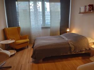 ein Schlafzimmer mit einem Bett, einem Stuhl und einem Fenster in der Unterkunft Mitte von Mitte - Blick auf den Turm in Berlin