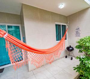 - un hamac orange sur le côté de la maison dans l'établissement casa de veraneio - casa 9 - condomínio azul mar - Porto de Galinhas, à Porto de Galinhas