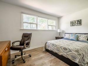 a bedroom with a bed and a desk and a chair at Gorgeous 4BR House with pool in Mississauga