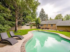 una piscina con 2 sillas junto a una casa en Gorgeous 4BR House with pool, en Mississauga