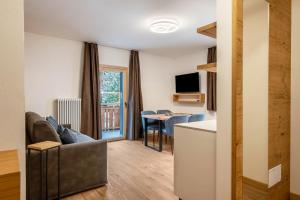 a living room with a couch and a table at Kamerloy Apartments A in Campitello di Fassa
