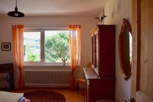 Cette chambre dispose d'une fenêtre avec un rideau orange. dans l'établissement Ferienwohnung Ruth, à Neustadt an der Weinstraße