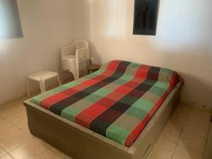 um quarto com uma cama com um cobertor colorido em Casa Beira Mar - Enseada dos Golfinhos em Itamaracá
