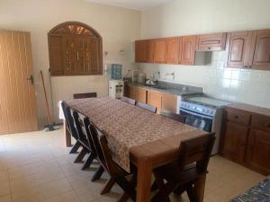 cocina con mesa con sillas y cocina con fogones en Casa Beira Mar - Enseada dos Golfinhos en Itamaracá