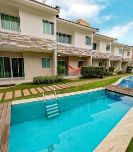una casa con piscina frente a ella en casa de veraneio - casa 9 - condomínio azul mar - Porto de Galinhas en Porto De Galinhas