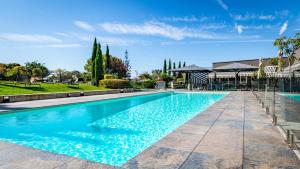 ein großes Schwimmbecken mit blauem Wasser in der Unterkunft Novotel Reims Tinqueux in Reims