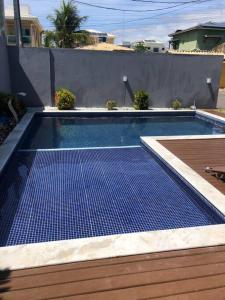 una piscina con un tappetino blu in un cortile di Casa Temporada Jacuípe Guarajuba 3/4 c/ar condicionado a Camaçari