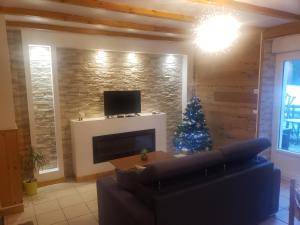 ein Wohnzimmer mit einem Weihnachtsbaum und einer Couch in der Unterkunft Appartement 4 personnes tout équipé VOSGES. in Rochesson