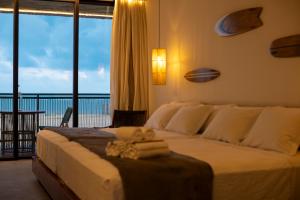 Schlafzimmer mit einem großen Bett und Meerblick in der Unterkunft Nanii Hotel in São Miguel do Gostoso
