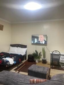 a living room with a bed and a tv on the wall at Zuhura homes in Ruiru