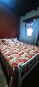 een bed met een rood en wit dekbed in een kamer bij F R F departamentos turisticos Nº 2 in San Rafael