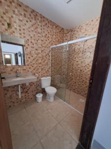 a bathroom with a toilet and a shower and a sink at Residencial Dona Francisca in Florianópolis
