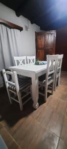 een witte tafel met vier stoelen eromheen bij F R F departamentos turisticos Nº 2 in San Rafael
